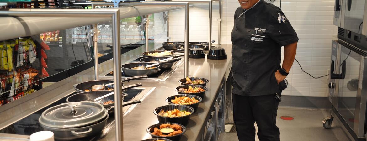 Chef Lanette Dickerson stands behind an ordering calendar with prepared Noods bowls.