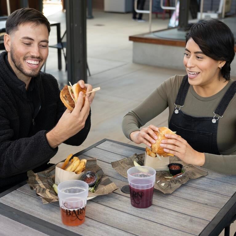 Two people eat outside at the Barn.