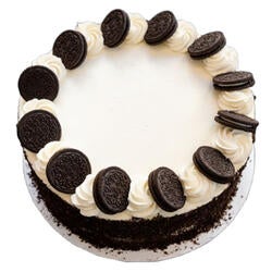 white cake with oreo crumbs on the side and oreos on top