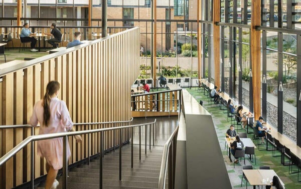 student walking down stairs in Glasgow atrium