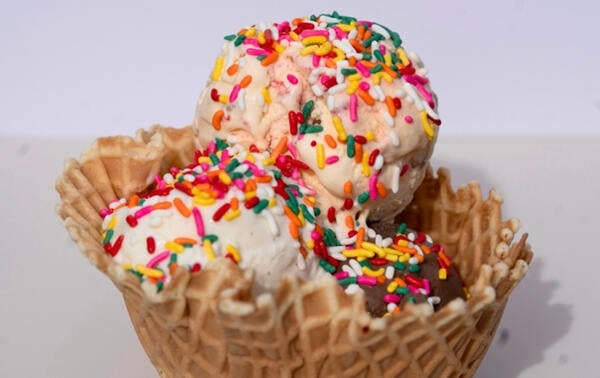 three scoop ice cream in cone with sprinkles