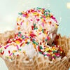 Three scoops of ice cream in a cone with sprinkles on top from Scoops.