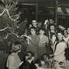 A black and white photo of people decorating a Christmas tree at the Barn.