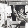 A black and white photo of a ticket seller and ticket buyers at the Barn.