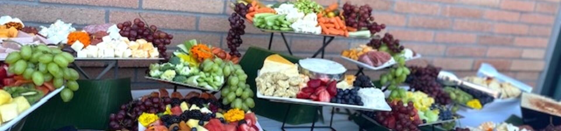 A tiered contemporary grazing table featuring artisanal charcuterie, cheeses, and fresh fruits.